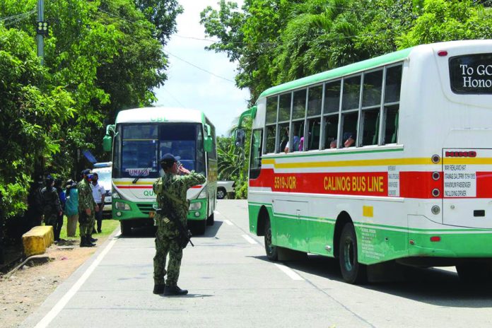 Police officers man a checkpoint on the border between Tapaz, Capiz and Calinog, Iloilo on March 18 as part of precautionary measures to curb the spread of the dreaded coronavirus disease 2019. PDRRMO CAPIZ