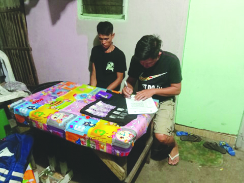 Antidrug officers inspect items seized from resident Ronrick Banaban, who was nabbed in an entrapment operation in Barangay Banago, Bacolod City on March 9. POLICE STATION 8/BCPO