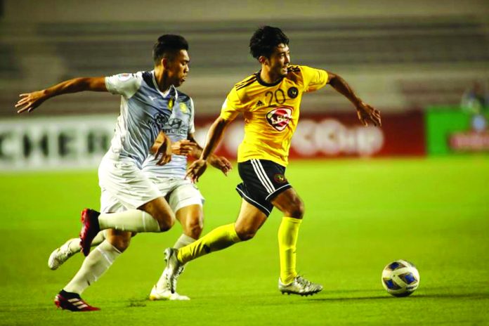 Kaya-Iloilo’s Daizo Horikoshi tries to get rid of defenders while controlling the ball. AFC