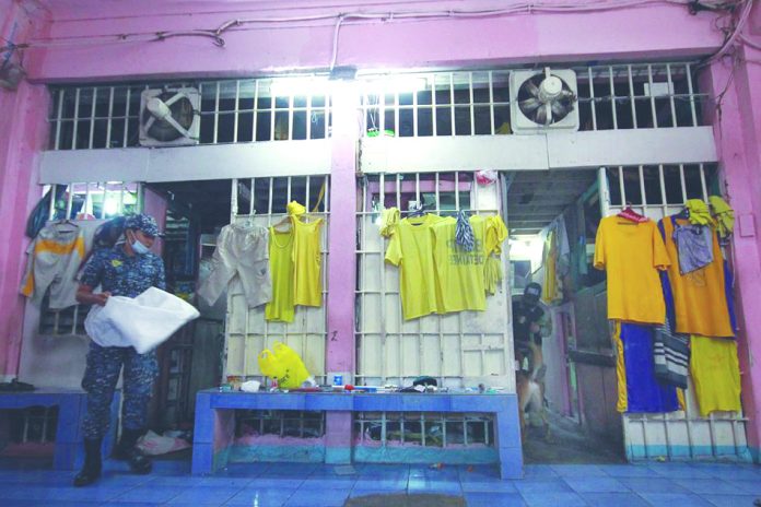 A Bureau of Jail Management and Penology personnel checks inmates’ cubicles inside the Quezon City Jail. Nine inmates and nine personnel of the detention facility have since been isolated after they contracted coronavirus disease 2019. ABS-CBN NEWS