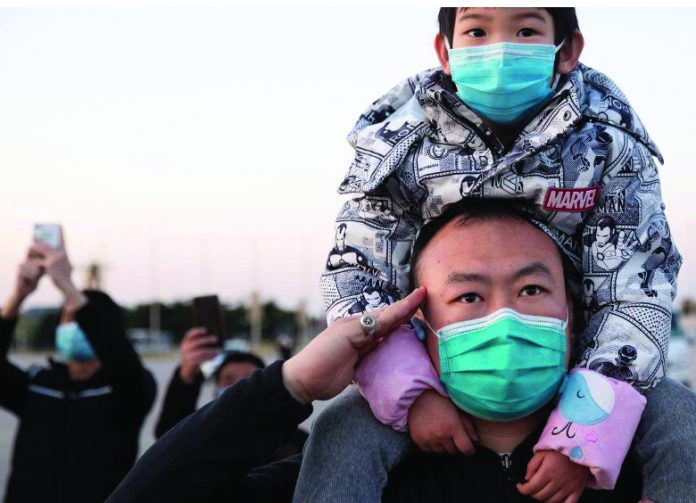 A man wearing a face mask salutes during a ceremony where the Chinese national flag is positioned at half-mast, at Tiananmen Square in Beijing as China holds a national mourning for those who died of the coronavirus disease, on the Qingming tomb-sweeping festival, April 4, 2020. CHINA DAILY VIA REUTERS