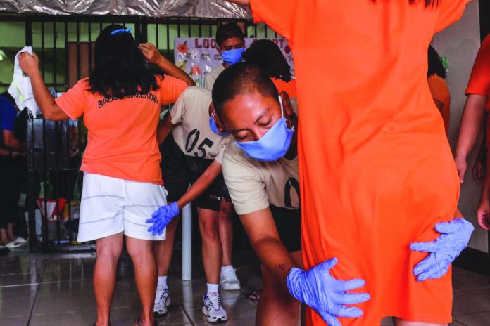 Bureau of Corrections personnel frisk people deprived of liberty inside the Correctional Institution for Women in Mandaluyong City. Twenty-seven female inmates inside the jail facility have been found out to be positive for coronavirus disease 2019. ABS-CBN NEWS