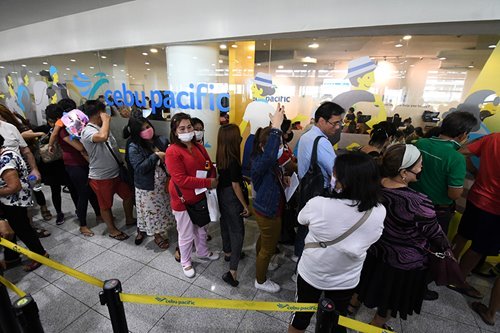 Passengers line up at Cebu Pacific’s booking office at the NAIA Terminal 3 in Pasay City on Mar. 13, 2020. ABS-CBN