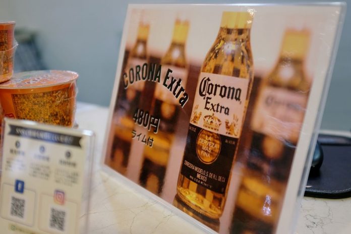 A sign advertising discounted Corona beers is displayed at the front desk of the Osaka Corona Hotel in Osaka, Japan March 19, 2020. Picture taken March 19, 2020. REUTERS