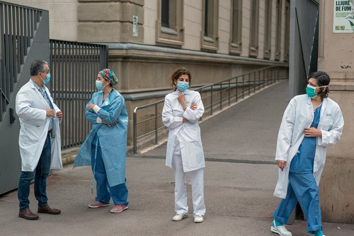 Health care workers take a break from work at a hospital in Barcelona on Mar. 24, 2020. Chinese customs officials, facing accusations from Europe that some medical supplies have been defective, have begun inspecting every shipment of medical supplies for quality issues before export. THE NEW YORK TIMES