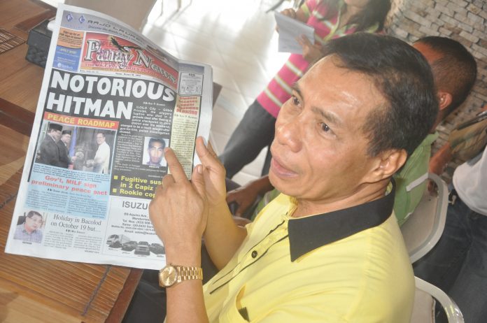 DANNY FAJARDO holds an October 16, 2012 issue of Panay News