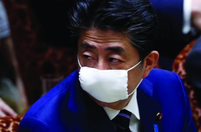 Japan's Prime Minister Shinzo Abe wears a protective face mask as he attends an upper house parliamentary session, following an outbreak of the coronavirus disease (COVID-19), in Tokyo, Japan April 1, 2020. REUTERS