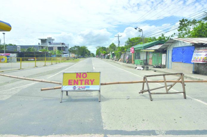 A makeshift barricade with no entry sign blocks the entrance to Barangay Tabucan, Barotac Nuevo, Iloilo. The said village was placed under heightened community quarantine after authorities recorded the first coronavirus disease 2019 case of the town. IAN PAUL CORDERO/PN