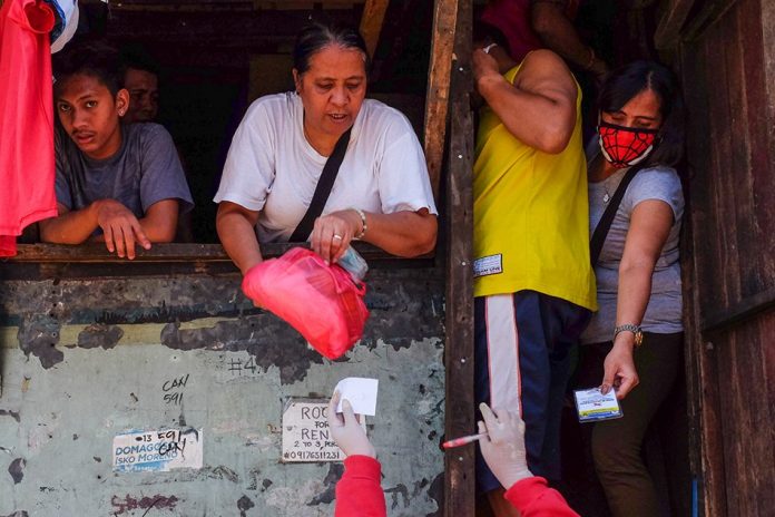 Volunteers distribute goods in Barangay Batis, San Juan City on Mar. 23, 2020. ABS-CBN