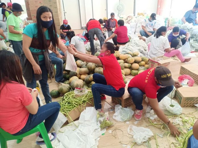 Personnel of the local government unit of Sara, Iloilo and volunteers prepare food packs to be distributed to the town’s residents on April 1. Beneficiaries will receive vegetables aside from the usual food packs. SARA GUGMA KO