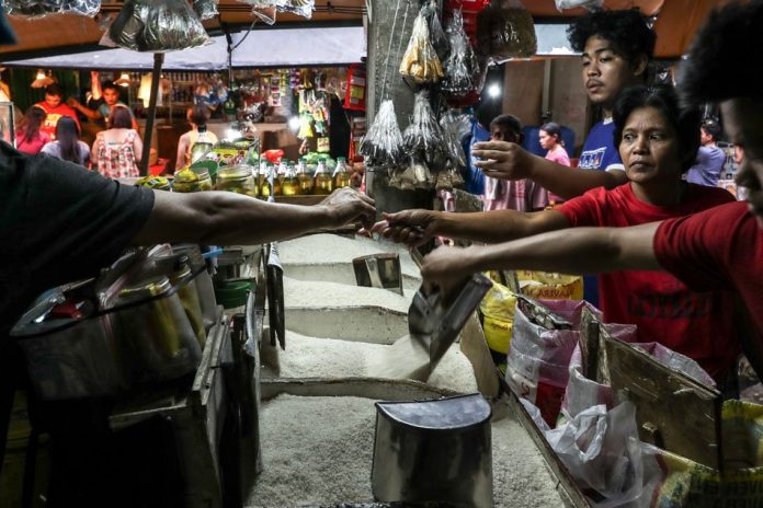 People buy rice at a residential street market in Manila, Feb. 7, 2018. ABS-CBN