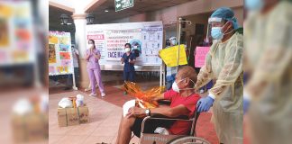 Medical frontliners of the Dr. Rafael S. Tumbukon Memorial Hospital (DRSTMH) in Kalibo, Aklan congratulate the 81-year-old coronavirus disease 2019 survivor who got discharged on April 22. He was sent to his residence in Libacao, Aklan for a 14-day mandatory quarantine. JUN AGUIRRE/PN