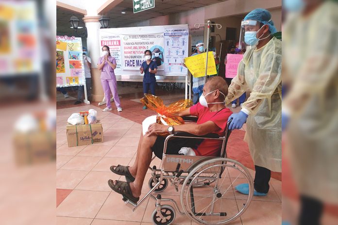 Medical frontliners of the Dr. Rafael S. Tumbukon Memorial Hospital (DRSTMH) in Kalibo, Aklan congratulate the 81-year-old coronavirus disease 2019 survivor who got discharged on April 22. He was sent to his residence in Libacao, Aklan for a 14-day mandatory quarantine. JUN AGUIRRE/PN