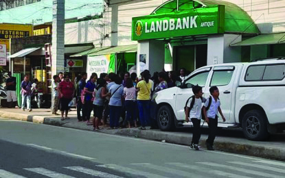 Beneficiaries of the Pantawid Pamilyang Pilipino Program wait outside a bank in this province before withdrawing their cash grant. PNA