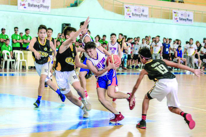 Bacolod Tay Tung High School’s Nathan Jundana attempts to score on the paint against Cebu City defenders during the Visayas qualifier of the 2019 Philippine Youth Games-Batang Pinoy (PYG-BP) in Iloilo City. The Philippine Sports Commission cancelled this year’s edition of the PYG-BP and the Philippine National Games due to the ongoing scare of coronavirus disease 2019. IAN PAUL CORDERO