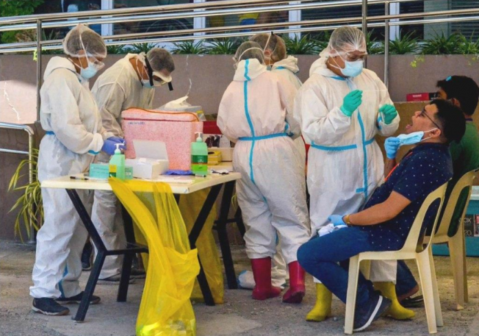 Fully covered with personal protective equipment, these healthcare personnel of the Iloilo City government are tasked to extract specimens from clients for analysis at the Western Visayas Medical Center laboratory. The city government is ramping up mass testing for coronavirus disease. IAN PAUL CORDERO/PN