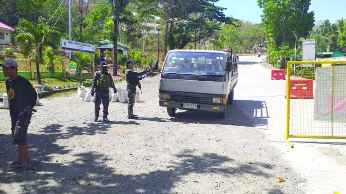 Police personnel conduct quarantine checkpoint at the border of Barangay Fabrica, Hamtic, Antique. An ambulance driver was arrested there on May 7 for transporting nine boxes of liquor. PNP HAMTIC ANTIQUE