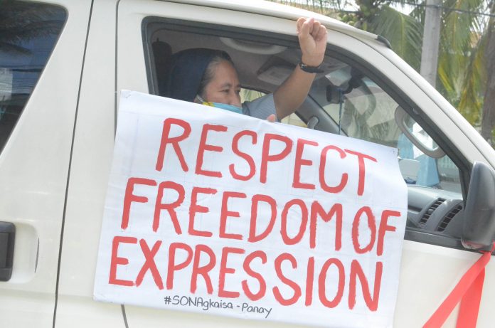 A member of a religious group holds a placard expressing support for press freedom during a protest caravan in Iloilo City on July 24. Police authorities are urging protesters to air their grievances for President Rodrigo Duterte’s fifth State of the Nation Address trough social media. IAN PAUL CORDERO/PN