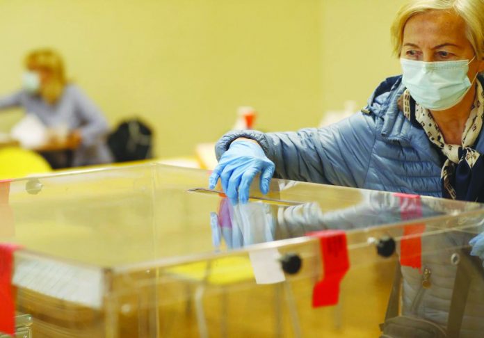 A woman casts her vote during presidential runoff election in Krakow, Poland, Sunday, July 12, 2020. AP PHOTO/PETR DAVID JOSE