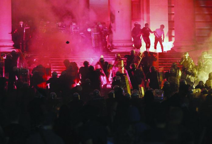 Protesters clash with riot police on the steps of the Serbian parliament during a protest in Belgrade, Serbia, Friday, July 10 2020. AP