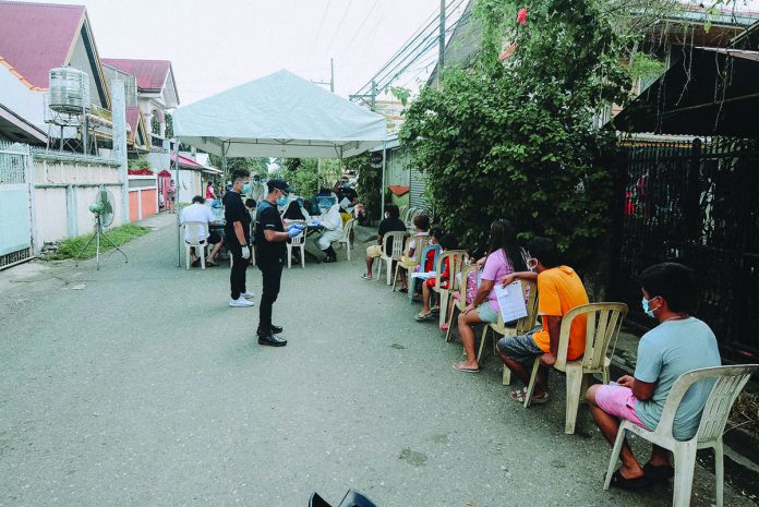 Residents queue to get tested for coronavirus disease 2019 at an extraction point in Zone 2, Barangay Bo. Obrero, Lapuz, Iloilo City on July 27. Five residents there were found infected with the viral illness. IAN PAUL CORDERO/PN