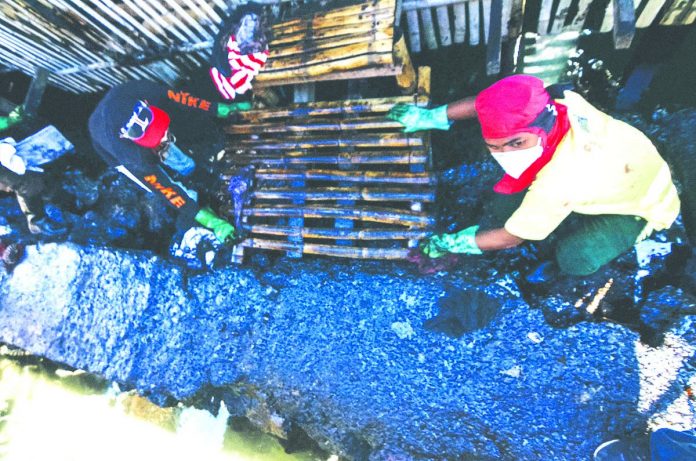 These residents of Barangay Bo. Obrero, Lapuz, Iloilo City help in the cleanup operation of the oil spill from Power Barge 102. Prolonged exposure the spilled bunker oil may bring adverse health effects, the Department of Health warns. IAN PAUL CORDERO/PN