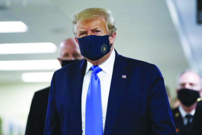 United States President Donald Trump wears a mask as he walks down the hallway during his visit to Walter Reed National Military Medical Center in Bethesda, Md., Saturday, July 11, 2020. AP PHOTO/PATRICK SEMANSKY