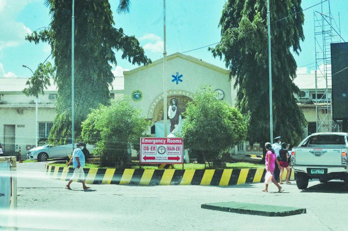 People walk past the front of Western Visayas Medical Center’s emergency room in Mandurriao, Iloilo City on Wednesday. Some portions of the hospital went on lockdown after three workers tested positive for coronavirus disease 2019. IAN PAUL CORDERO/PN