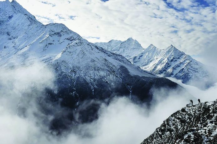 Agence France-Presse reporter Ammu Kannampilly (second from right) and Nepalese guide Pasang Sherpa stand on a ridge over a valley leading north into the Khumbu region as they try to get a clear view of Mt. Everest on April 18, 2015. AFP