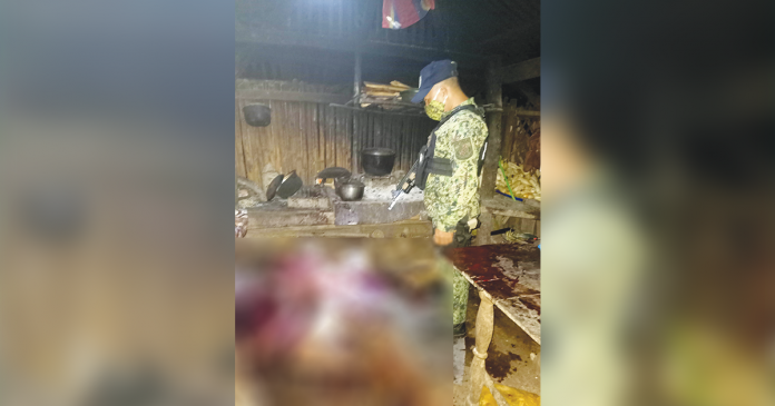 A police officer checks the body of Alex Ayon who was hacked to death by his younger brother Robert in Barangay Magsaysay, Culasi, Antique. CULASI MPS