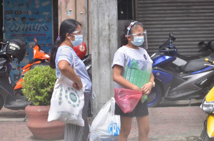 Aside from face masks, these women wear face shields while waiting for a jeepney ride in Iloilo City’s downtown area. Starting today, passengers of any mode of public transportation are required to wear face shield for protection against coronavirus disease 2019. IAN PAUL CORDERO/PN