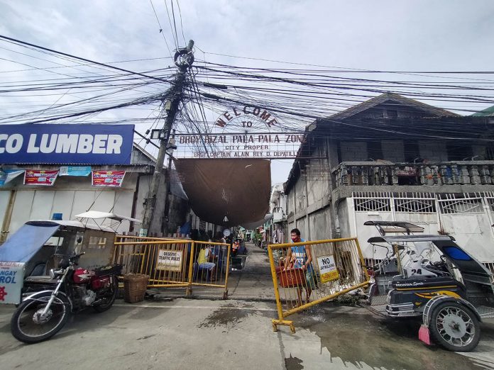 Barricades block the entrance of Barangay Pala-Pala 1 in Iloilo City on Monday. The village has four cases of coronavirus disease 2019. IAN PAUL CORDERO