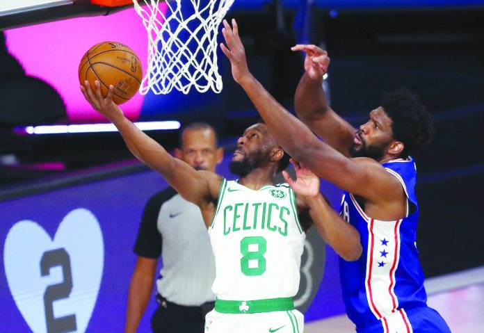 Boston Celtics’ Kemba Walker blows past the defense of Philadelphia 76ers’ Joel Embiid for a reverse basket. AP