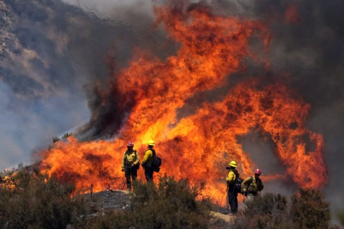 Firefighters work against the Apple Fire near Banning, Calif., Sunday, Aug. 2, 2020. AP