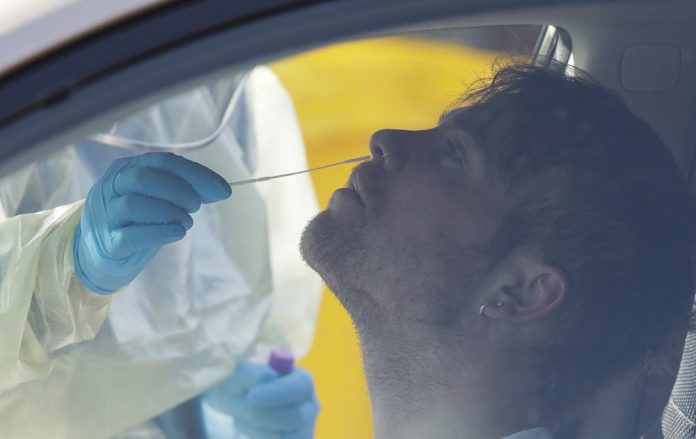 Medical staff take a COVID-19 test from a visitor to a drive through community based assessment centre in Christchurch, New Zealand, Thursday, Aug. 13, 2020. AP