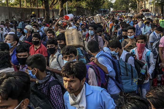 Migrant workers crowd outside a train station in Mumbai, India to board trains to their home state, Bihar, on May 20, 2020. Migrant workers are becoming infected with the coronavirus at an alarmingly high rate, leading to fresh outbreaks in villages across northern India. THE NEW YORK TIMES