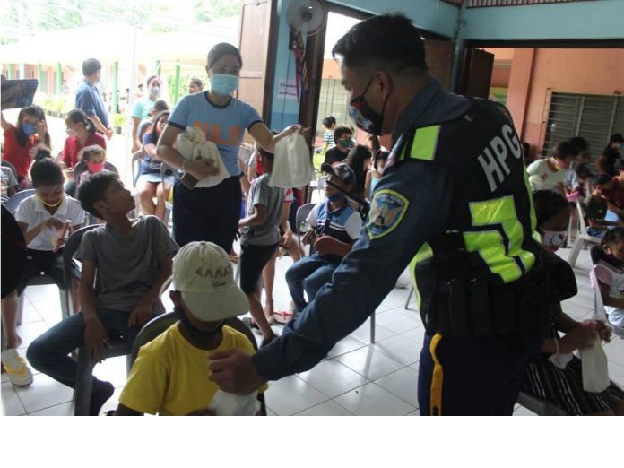 Police officers distribute gift packs to children at SOS Children’s Village in Zarraga, Iloilo. PRO-6 PHOTO