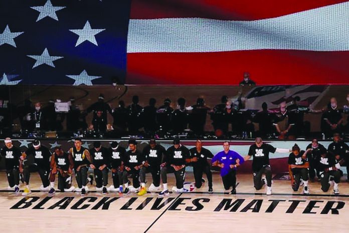 Players and coaches of Los Angeles Lakers and Los Angeles Clippers kneel as they sang the national anthem during their regular season match in Orlando, Florida. USA TODAY