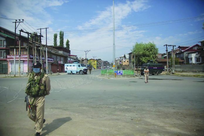 Policemen and paramilitary soldiers patrol a road during curfew in Srinagar, Indian controlled Kashmir, Tuesday, Aug. 4, 2020. AP