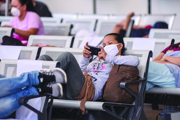 Stranded overseas Filipino workers rest at the waiting area of the NAIA Terminal 2 on May 29, 2020. ABS-CBN