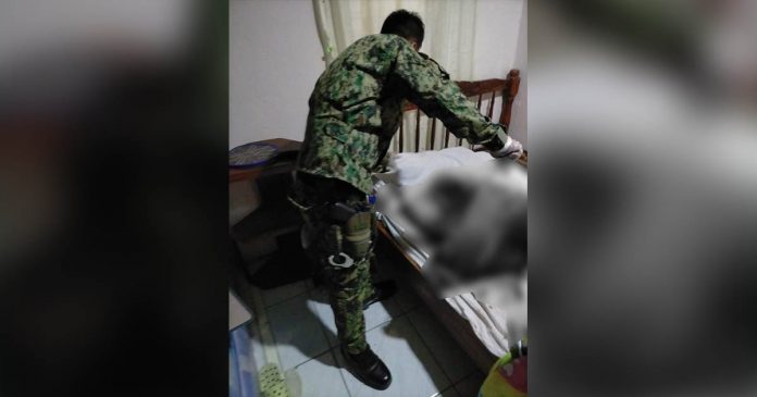 A police officer inspects the blood-soaked bed where elementary teacher Cecelia Adorador was killed. She was alone in her house in Purok 10, Barangay Aguisan, Himamaylan City, Negros Occidental, according to police investigators. HIMAMAYLAN CITY POLICE STATION