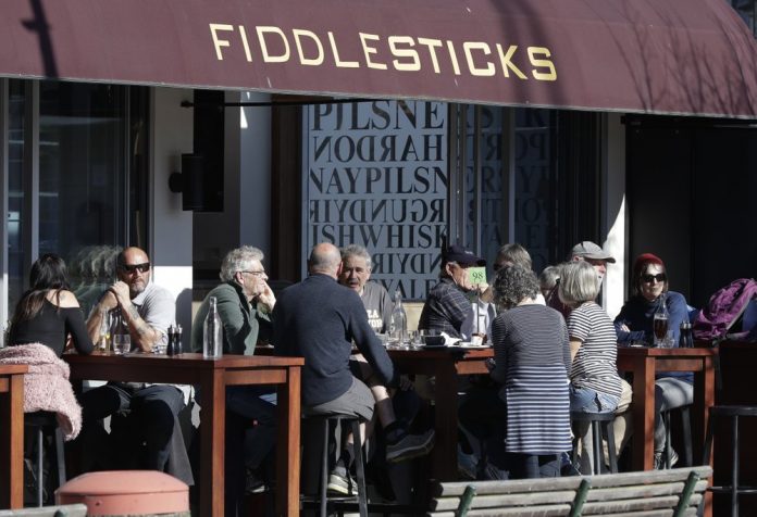 Customers at a cafe enjoy lunch in the sunshine in Christchurch, New Zealand, Sunday, Aug. 9, 2020. New Zealand marked a 100 days of being free from the coronavirus in its communities. AP