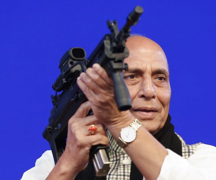 In this Feb. 7, 2020 file photo, Indian Defense Minister Rajnath Singh holds a model of a light machine gun during DefExpo20 in Lucknow, India. AP