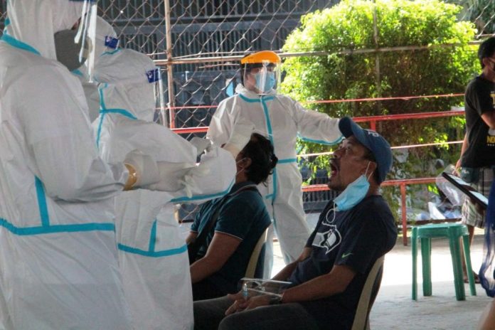 Personnel of the Bacolod City Health Office extract specimens from these residents during a simultaneous mass testing for coronavirus disease 2019 on Aug. 29, 2020. Local authorities are ramping up virus testing to determine how widespread the viral disease has become. ARCHIE ALIPALO/PN