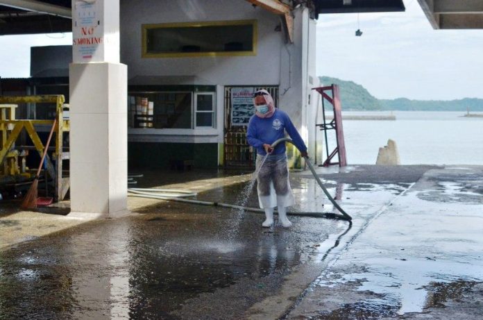 A personnel clean the Iloilo Fish Port Complex in Barangay Tanza, Iloilo City. For three days the complex would be disinfected (Aug. 2-4, 2020). Bagnetters and other fishing bancas must divert their fish haul to other ports. IAN PAUL CORDERO/PN