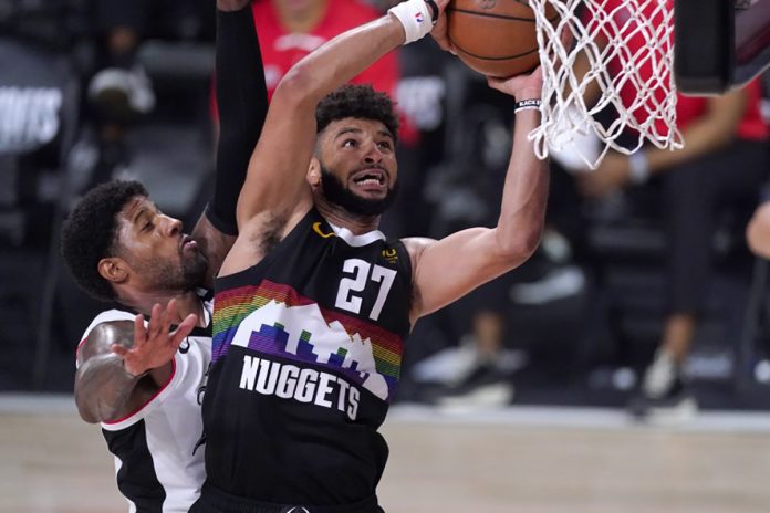 Denver Nuggets’ Jamal Murray goes up for a shot as Clippers’ Paul George defends during the second half on Sunday in Orlando, Florida. MARK J. TERRILL / AP