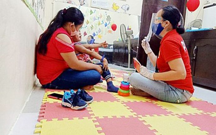 In this July 2020 file photo, physical therapist Angie Liz Vagilidad (right) conducts therapy session to a four-year at the Community Based Inclusive Development Unit Therapy Center of the provincial government in San Jose, Antique. PNA