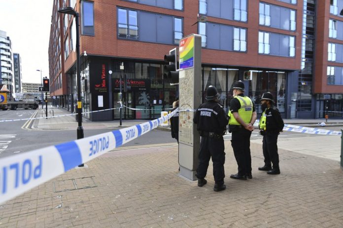 A police officer and vehicles are seen at a cordon in Irving Street in Birmingham after a number of people were stabbed in the city centre, Sunday, Sept. 6, 2020. JACOB KING/PA VIA AP