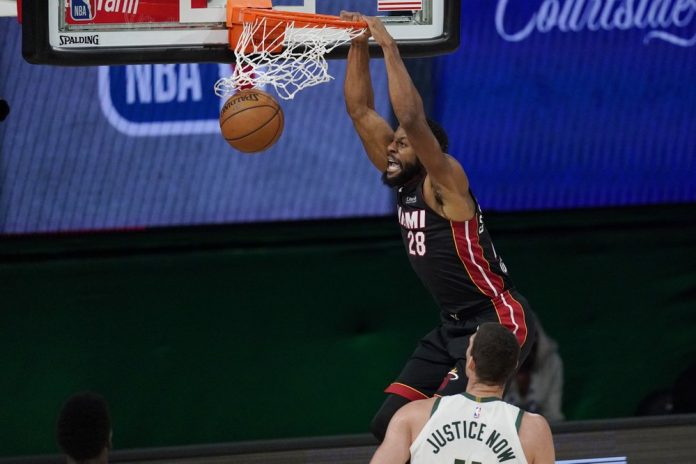 Miami Heat’s Andre Iguodala dunks in front of Milwaukee Bucks’ Brook Lopez in Game 5 of their Eastern Conference semifinals match. MARK J. TERRILL/AP PHOTO