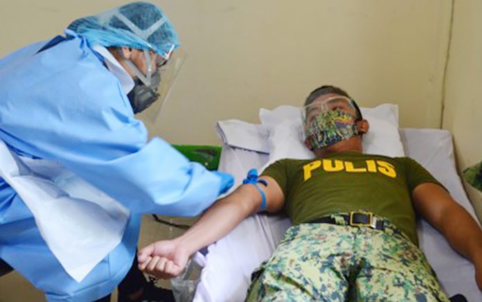 BLOOD DONOR A police officer of the Negros Occidental Police Provincial Office, who has fully recovered from coronavirus disease, donates convalescent plasma to the Corazon Locsin Montelibano Memorial Regional Hospital Blood Bank on Sept. 26, 2020. NOCPPO